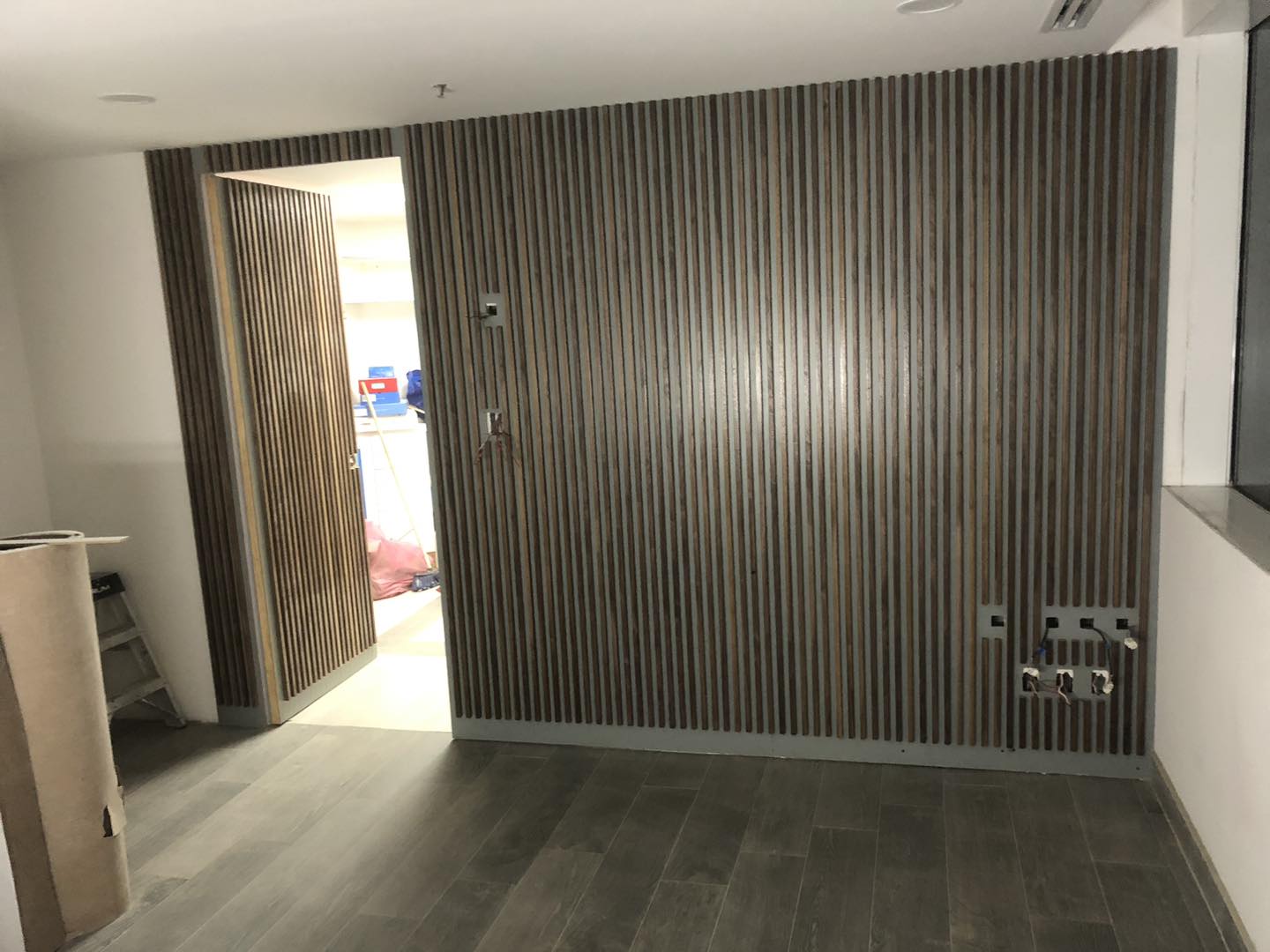 Pared de listones de madera con puerta oculta integrada