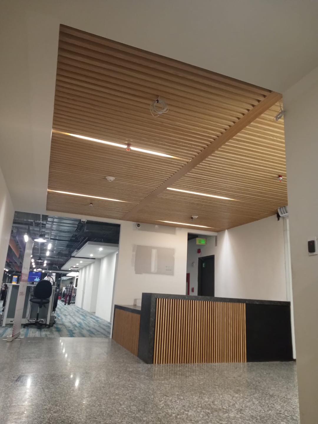 Recepción corporativa con techo de listones de madera