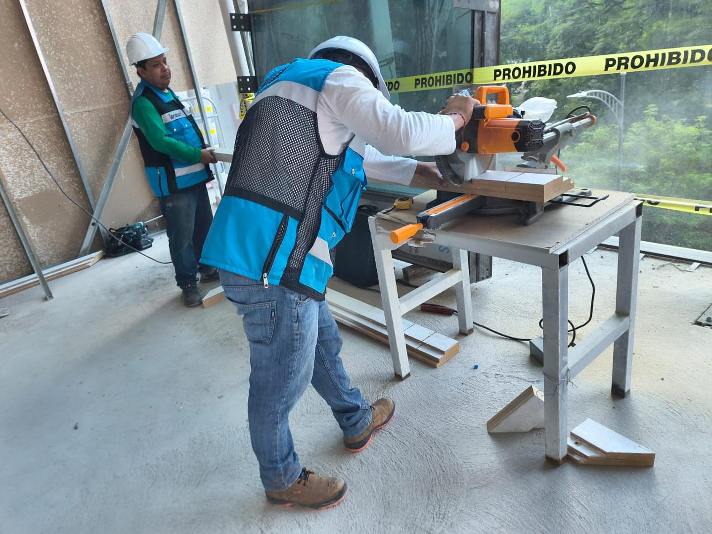 Trabajadores con equipo de protección cortando madera