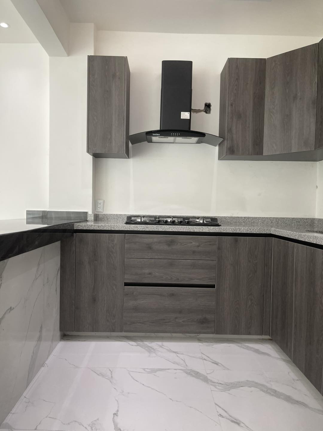 Cocina moderna remodelada con gabinetes grises por Constructora Boss